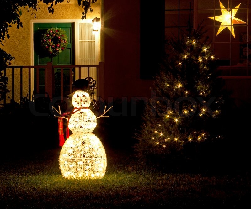 3177435-christmas-decorations-snowman-and-christmas-tree-with-lights-on-green-grass